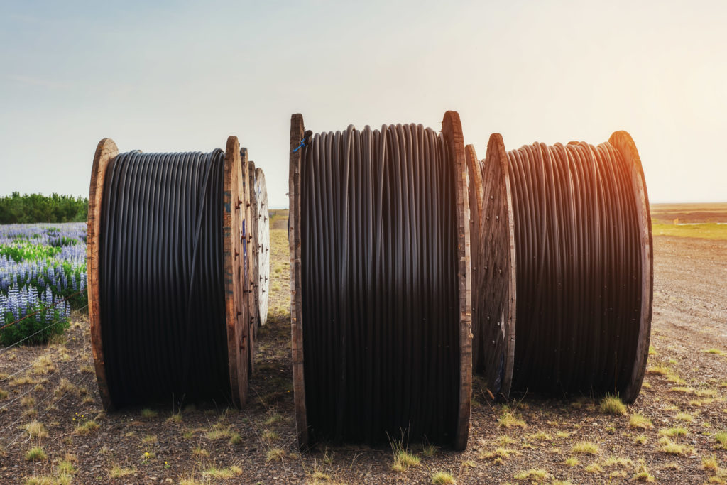 Large rolls of black wires against the blue sky at sunset